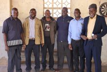 Sechs Männer der Diabetes-Selbsthilfegruppe in Chikombedzi stehen nebeneinander und lächeln in die Kamera.